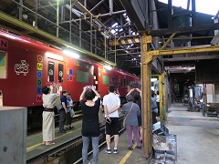 車庫の中で電車の横に立つ参加者