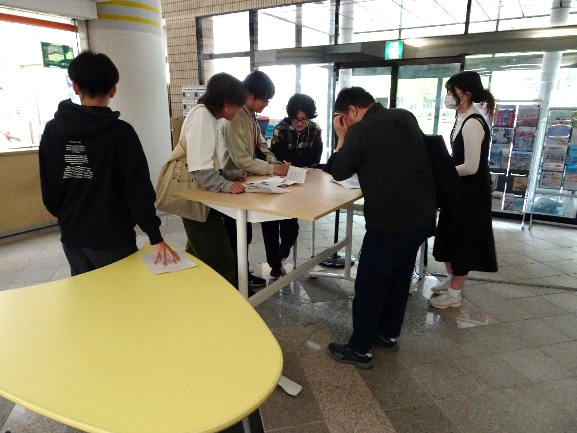 机を囲んで謎を解いているようす。