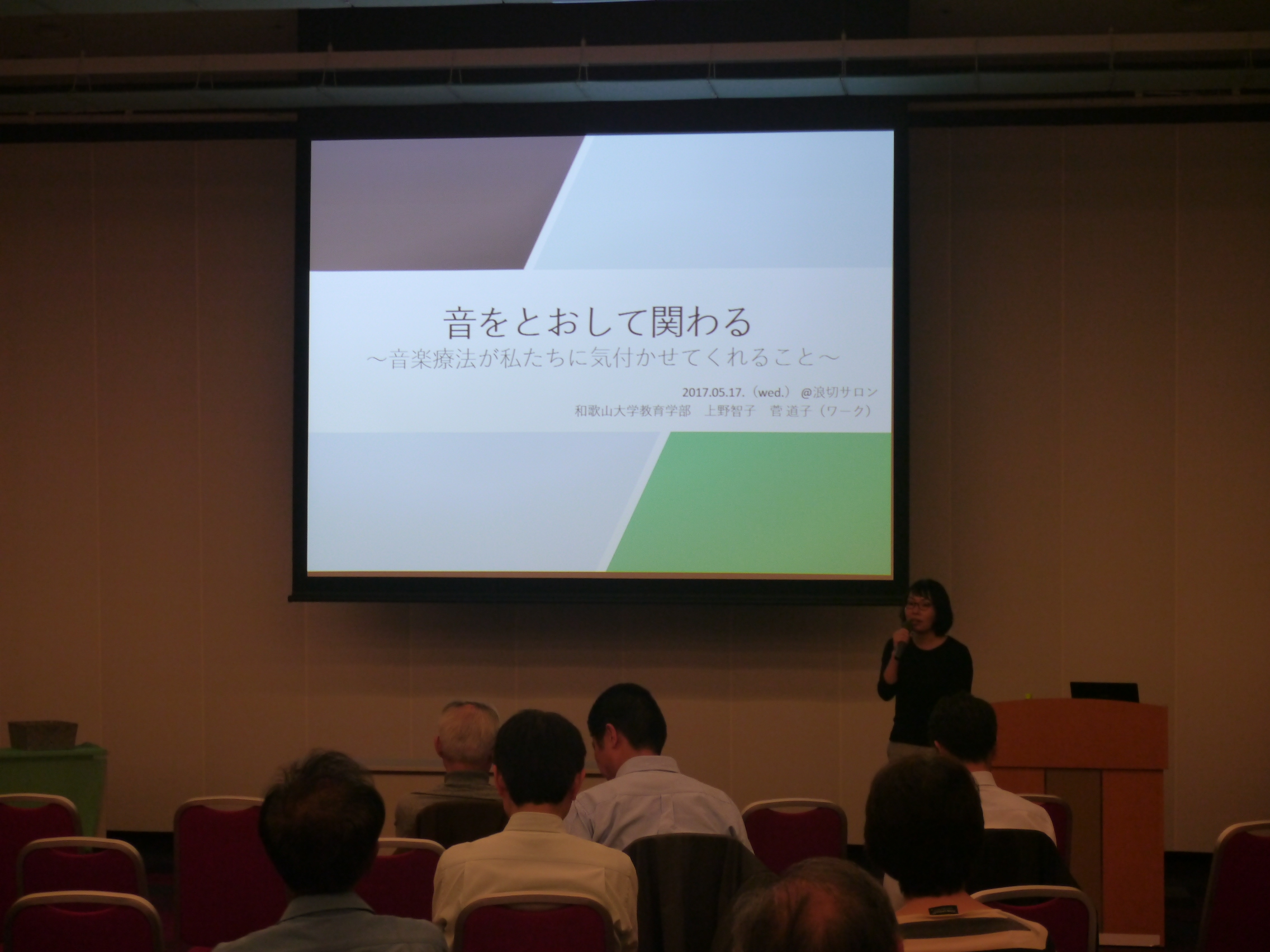 講師がスクリーンの前で話している様子 講師がスクリーンの前で話している様子