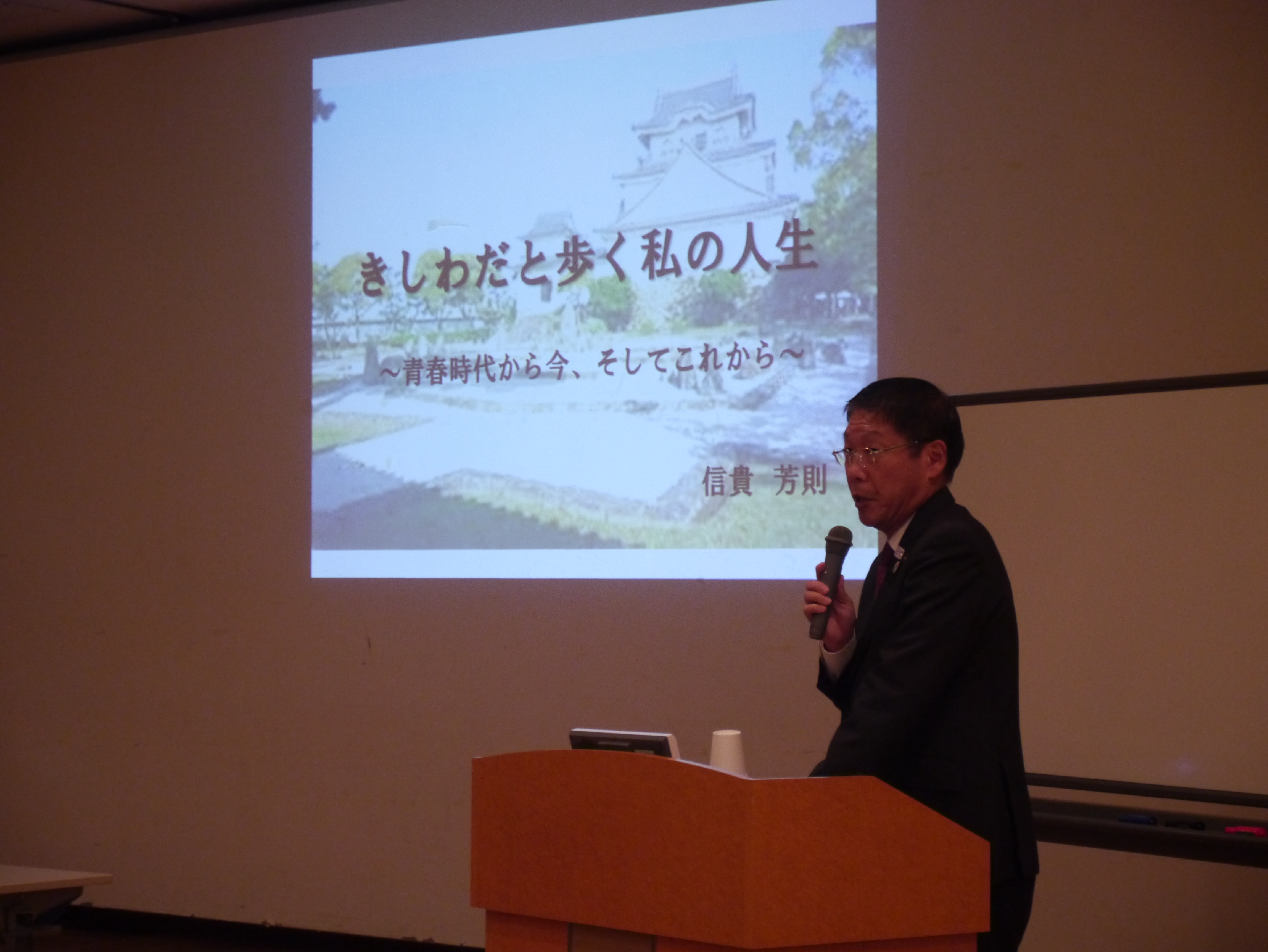 スクリーンの横に立って話をする信貴芳則岸和田市長 スクリーンの横に立って話をする信貴芳則岸和田市長