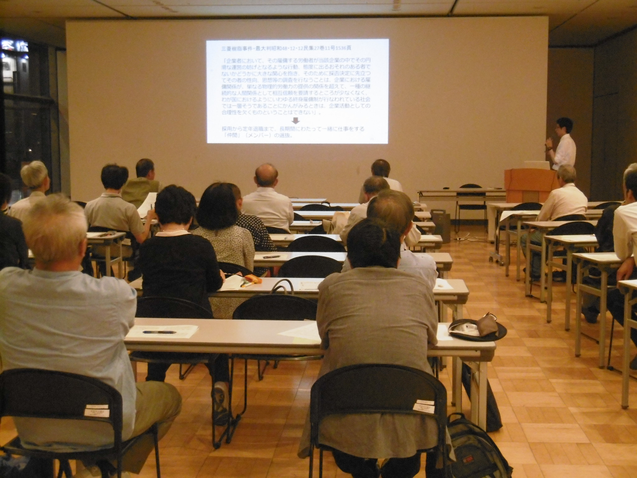 スクリーンの横に立って話をする植村新先生