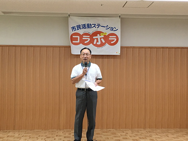マイクを持って話をする男性