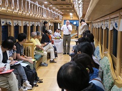 電車の中で地元の方の話を聞く参加者