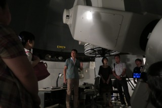 巨大望遠鏡を囲み先生の話を聞く参加者