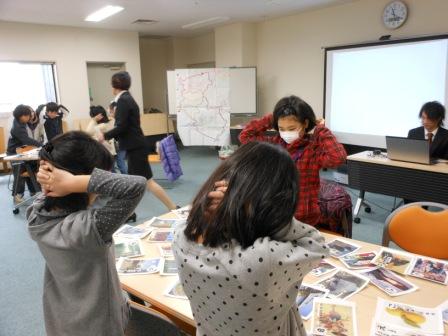 手を頭に置いて座る子供達