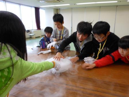 ドライアイスの気体に触れる子供たち