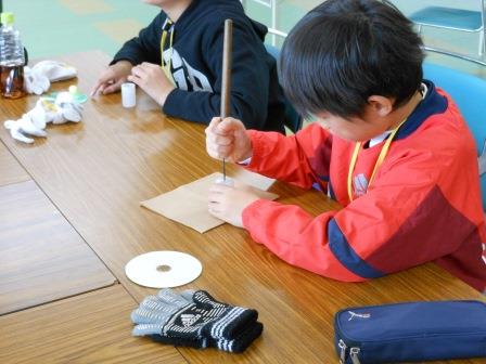 きりで穴を開ける子供