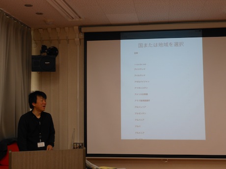 スクリーンの横に立って話す先生