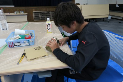 空き缶でリサイクル小物を作る子供