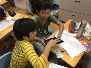 iPadのパズルアプリをする子供達