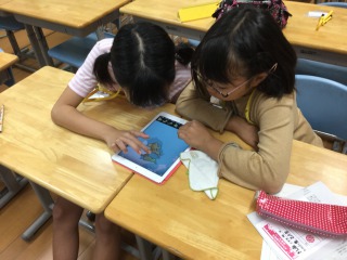 iPadのパズルアプリをする子供達