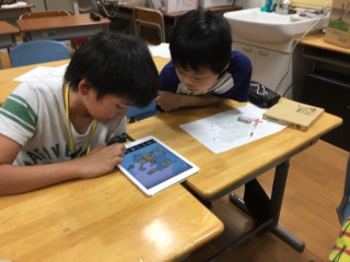 iPadのパズルアプリをする子供達