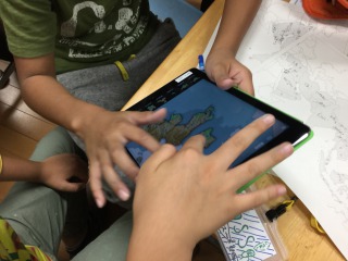 iPadのパズルアプリをする子供達