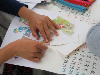 折り紙でできた飾りを貼る子供達