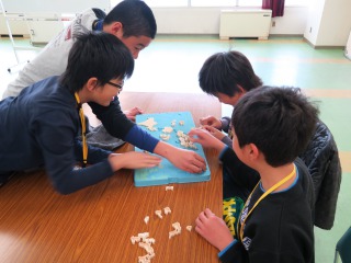 日本地図のパズルをする子供たち