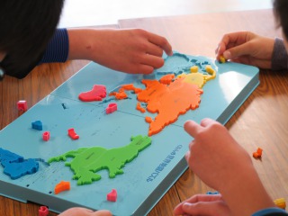 世界地図のパズルをする参加者
